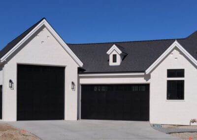 Beautiful white home with contrasting black garage doors