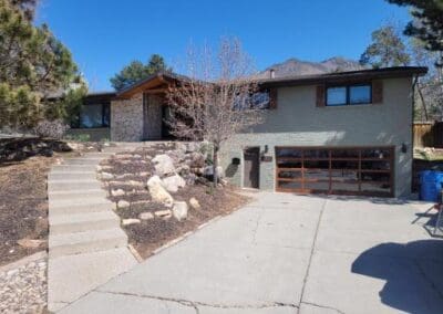 Green home with windowed glass garage door.