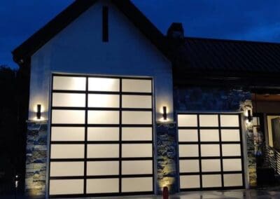 Front view of illuminated glass paneled garage doors