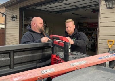 AAA Garage Door mechanics packing equipment into pick-up truck