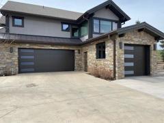 Stone edged home with a dark contrasting garage door