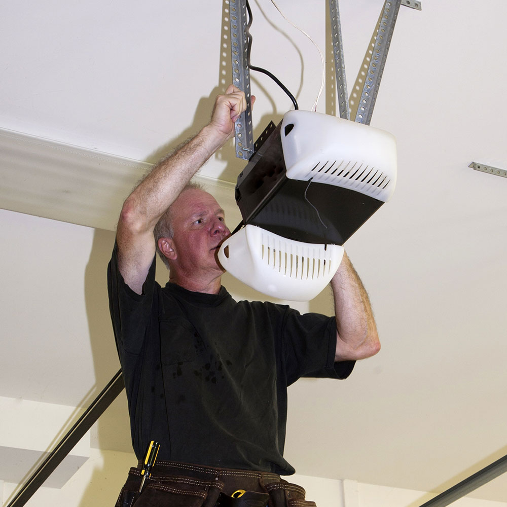 a person fixing a ceiling mounted light fixture