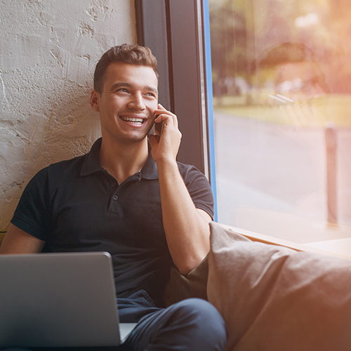 a person sitting on a couch talking on a cell phone